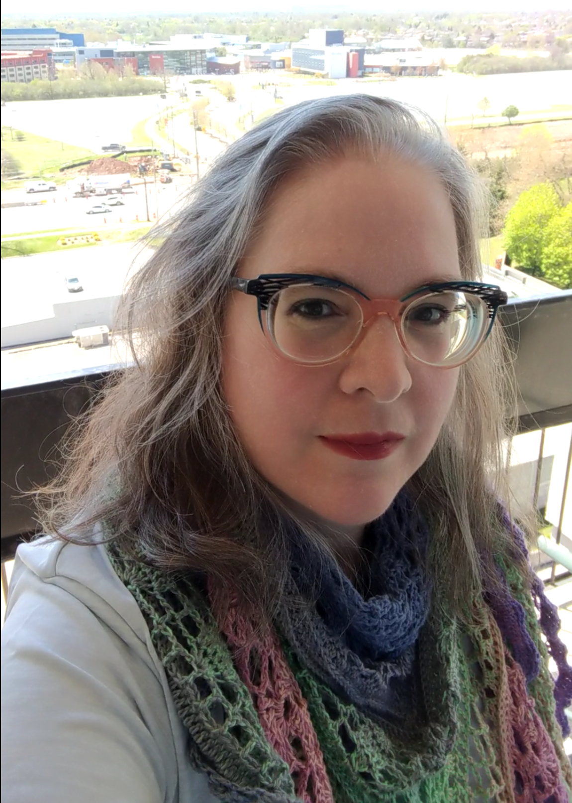 wendi wearing glasses, outside on a high-rise balcony